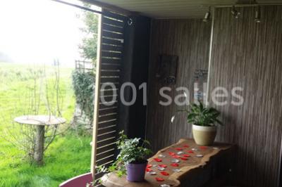 Table ronde décorée pour un repas, avec nappes blanches, couverts disposés, fleurs et éléments naturels en centre de table.