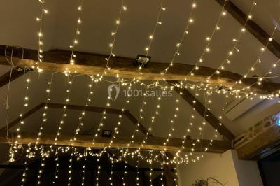 Table ronde décorée pour un repas, avec nappes blanches, couverts disposés, fleurs et éléments naturels en centre de table.