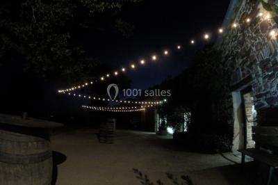 Table ronde décorée pour un repas, avec nappes blanches, couverts disposés, fleurs et éléments naturels en centre de table.