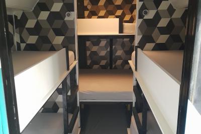 Table ronde décorée pour un repas, avec nappes blanches, couverts disposés, fleurs et éléments naturels en centre de table.