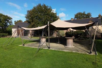 Table ronde décorée pour un repas, avec nappes blanches, couverts disposés, fleurs et éléments naturels en centre de table.