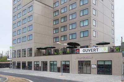 Façade d'un restaurant Courtepaille avec terrasse et enseigne ’OUVERT’, situé au rez-de-chaussée d'un immeuble moderne.