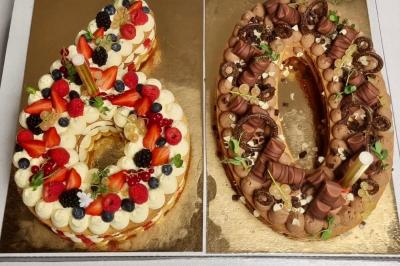Terrasse extérieure avec tables dressées sous des parasols, entourée de verdure et visible à travers une fenêtre.