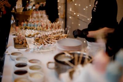 Terrasse extérieure avec tables dressées sous des parasols, entourée de verdure et visible à travers une fenêtre.