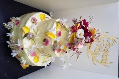 Terrasse extérieure avec tables dressées sous des parasols, entourée de verdure et visible à travers une fenêtre.