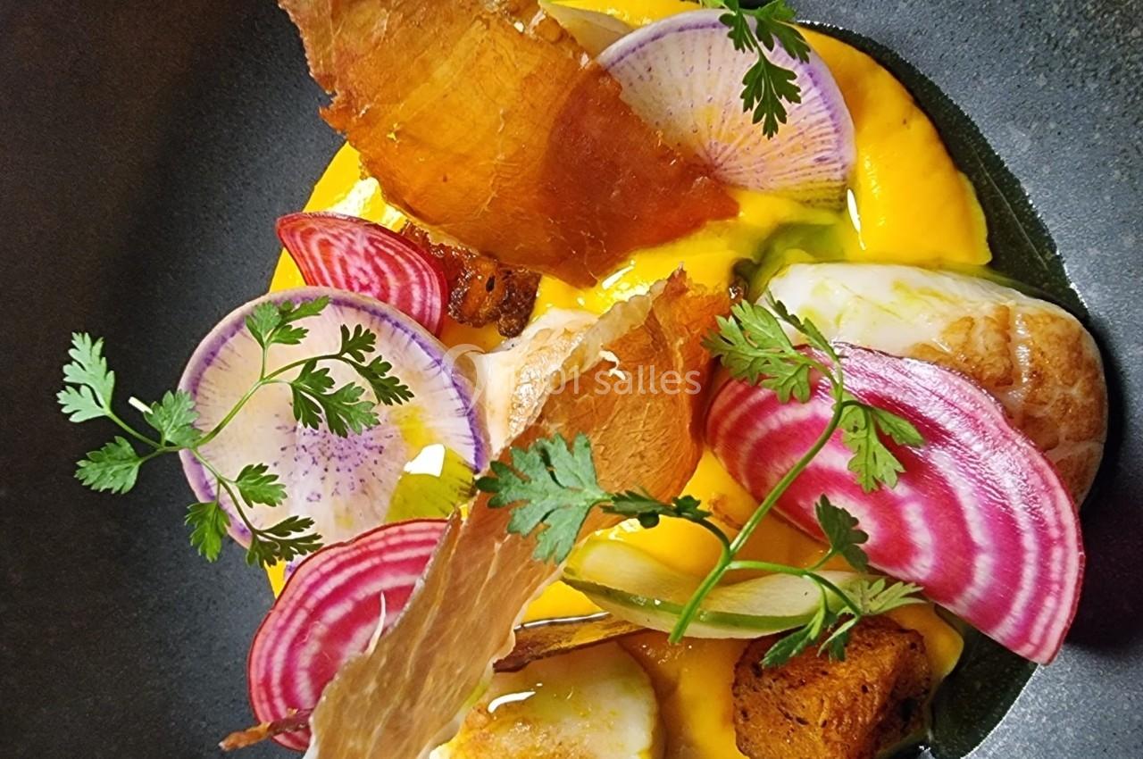 Assiette gastronomique avec noix de Saint-Jacques, purée orange, chips croustillantes et fines tranches de betterave.