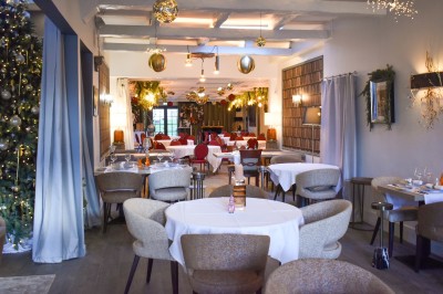 Équipe de restaurant posant en groupe devant un mur décoratif, avec deux enfants tenus par des adultes au centre.