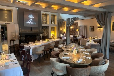 Équipe de restaurant posant en groupe devant un mur décoratif, avec deux enfants tenus par des adultes au centre.