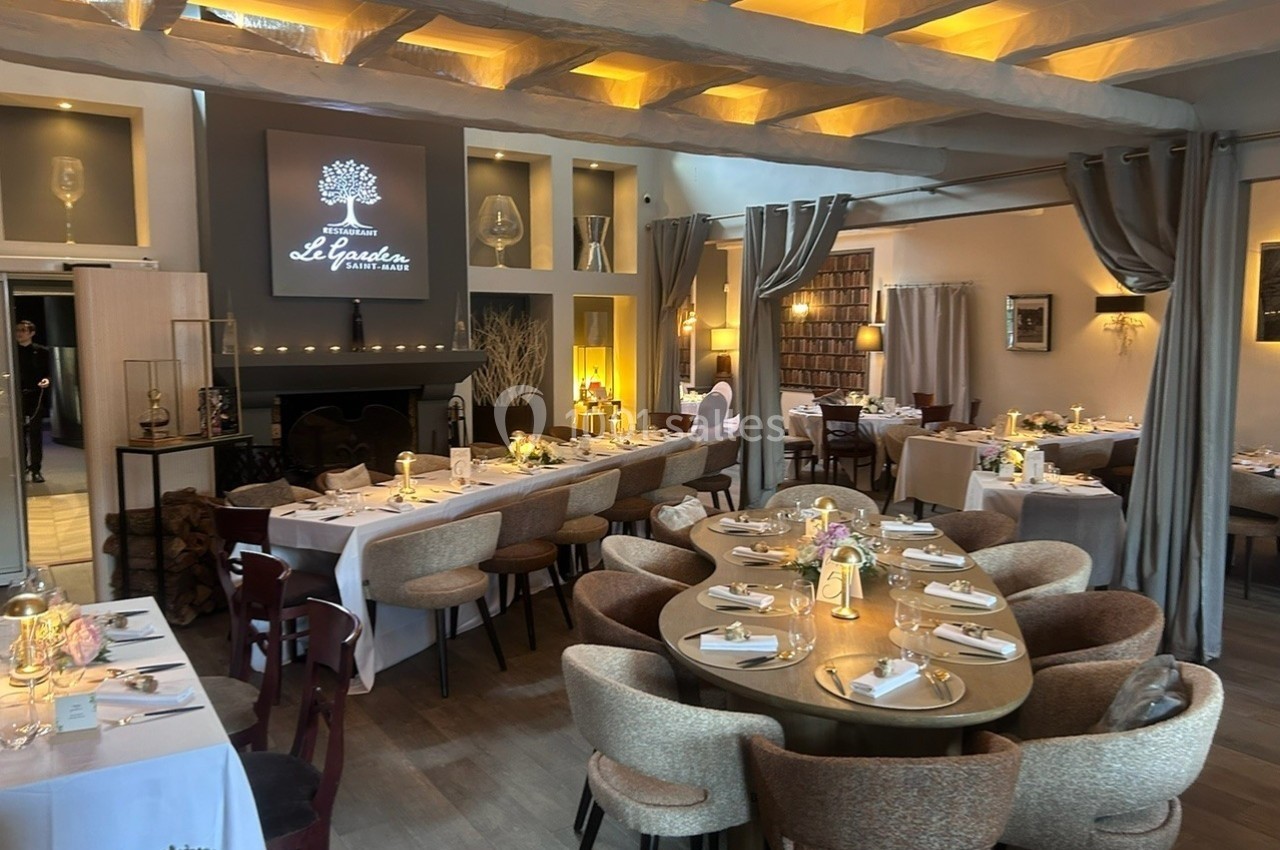 Salle de restaurant élégante avec tables dressées, éclairage chaleureux et décoration moderne.