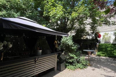 Équipe de restaurant posant en groupe devant un mur décoratif, avec deux enfants tenus par des adultes au centre.