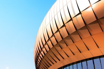 Flacons et éléments décoratifs sous cloches en verre sur une table éclairée dans un espace moderne et tamisé.