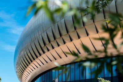 Flacons et éléments décoratifs sous cloches en verre sur une table éclairée dans un espace moderne et tamisé.