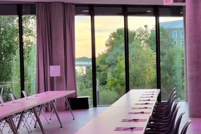 Flacons et éléments décoratifs sous cloches en verre sur une table éclairée dans un espace moderne et tamisé.