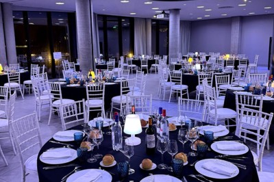 Flacons et éléments décoratifs sous cloches en verre sur une table éclairée dans un espace moderne et tamisé.