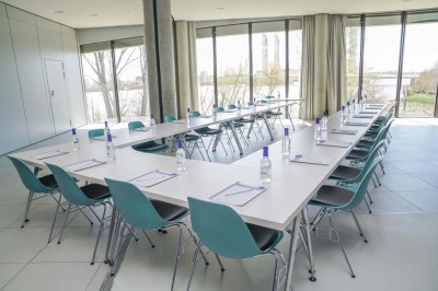 Flacons et éléments décoratifs sous cloches en verre sur une table éclairée dans un espace moderne et tamisé.
