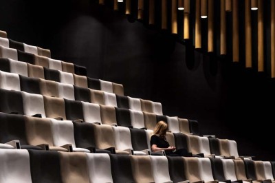 Flacons et éléments décoratifs sous cloches en verre sur une table éclairée dans un espace moderne et tamisé.