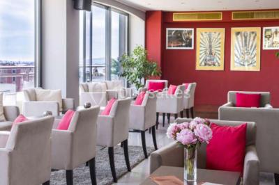 Miniature Location salle Nice (Alpes-Maritimes) - Aston La Scala Nice #11 Tables dressées avec chandelles et fleurs sur une terrasse offrant une vue nocturne sur des bâtiments éclairés.