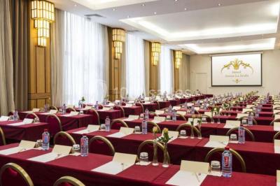 Miniature Location salle Nice (Alpes-Maritimes) - Aston La Scala Nice #4 Tables dressées avec chandelles et fleurs sur une terrasse offrant une vue nocturne sur des bâtiments éclairés.