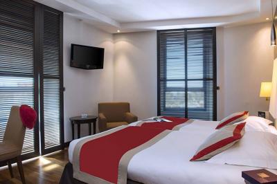 Miniature Location salle Nice (Alpes-Maritimes) - Aston La Scala Nice #21 Tables dressées avec chandelles et fleurs sur une terrasse offrant une vue nocturne sur des bâtiments éclairés.