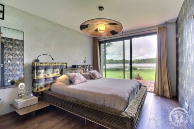 Chambre mansardée avec deux lits simples, murs en pierre apparente, lumière naturelle et décoration chaleureuse.