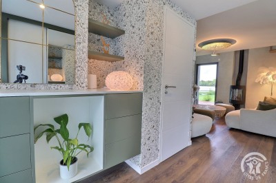 Chambre mansardée avec deux lits simples, murs en pierre apparente, lumière naturelle et décoration chaleureuse.