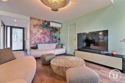Chambre mansardée avec deux lits simples, murs en pierre apparente, lumière naturelle et décoration chaleureuse.