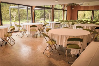Vue d'un étang entouré d'arbres et de végétation dense, reflétant la lumière douce du matin.