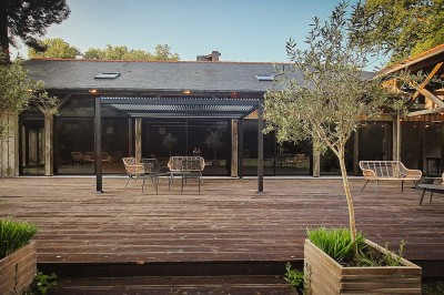 Vue d'un étang entouré d'arbres et de végétation dense, reflétant la lumière douce du matin.