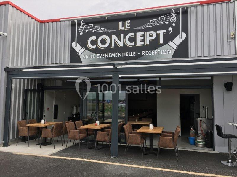 Façade d'une salle événementielle avec terrasse aménagée de tables et chaises sous une pergola.