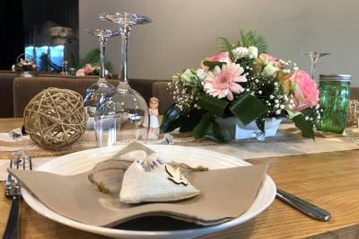 Salle décorée pour un anniversaire avec ballons noirs et dorés, tables dressées et une scène en fond.