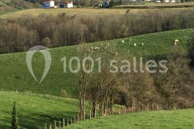 Chambre lumineuse avec poutres apparentes, lit double, commode en bois et fenêtres donnant sur l'extérieur.