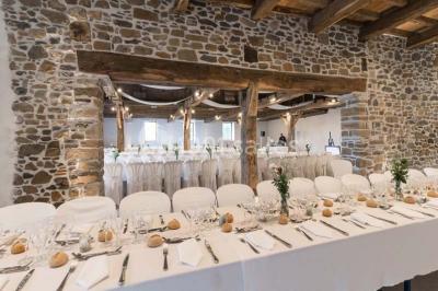 Chambre lumineuse avec poutres apparentes, lit double, commode en bois et fenêtres donnant sur l'extérieur.