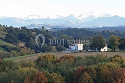 Chambre lumineuse avec poutres apparentes, lit double, commode en bois et fenêtres donnant sur l'extérieur.