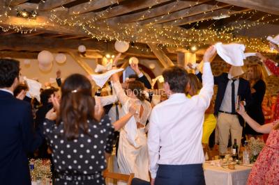 Chambre lumineuse avec poutres apparentes, lit double, commode en bois et fenêtres donnant sur l'extérieur.