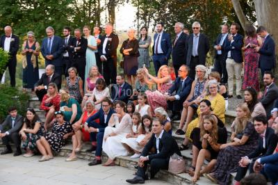Chambre lumineuse avec poutres apparentes, lit double, commode en bois et fenêtres donnant sur l'extérieur.