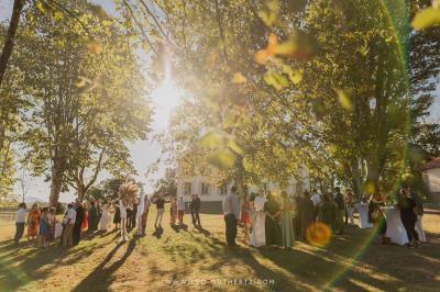 Chambre lumineuse avec poutres apparentes, lit double, commode en bois et fenêtres donnant sur l'extérieur.