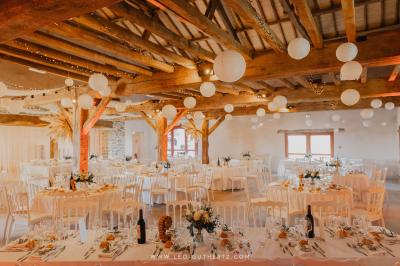 Chambre lumineuse avec poutres apparentes, lit double, commode en bois et fenêtres donnant sur l'extérieur.