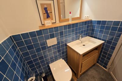 Chambre lumineuse avec poutres apparentes, lit double, commode en bois et fenêtres donnant sur l'extérieur.