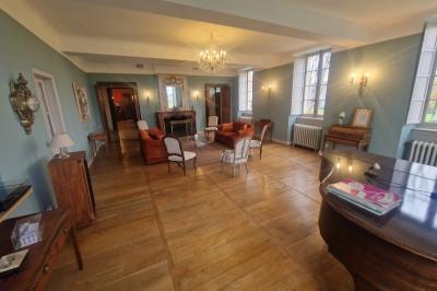 Chambre lumineuse avec poutres apparentes, lit double, commode en bois et fenêtres donnant sur l'extérieur.
