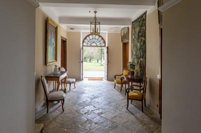 Chambre lumineuse avec poutres apparentes, lit double, commode en bois et fenêtres donnant sur l'extérieur.