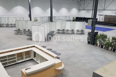 Entrée vitrée illuminée avec des plantes en pot disposées en rangées et éclairage coloré.