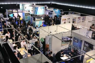 Entrée vitrée illuminée avec des plantes en pot disposées en rangées et éclairage coloré.