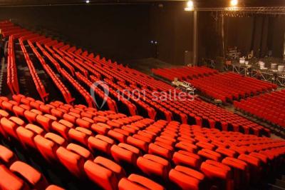 Entrée vitrée illuminée avec des plantes en pot disposées en rangées et éclairage coloré.