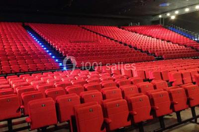 Entrée vitrée illuminée avec des plantes en pot disposées en rangées et éclairage coloré.