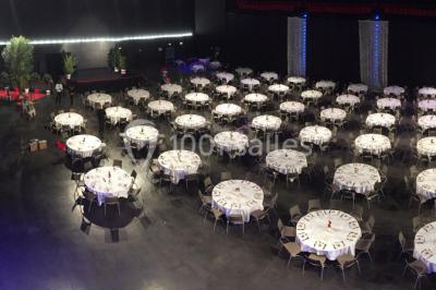 Entrée vitrée illuminée avec des plantes en pot disposées en rangées et éclairage coloré.