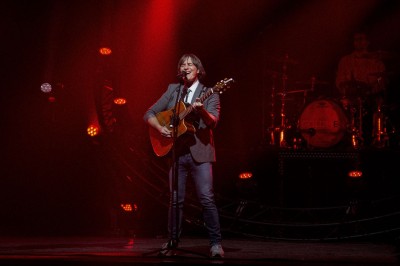 Entrée vitrée illuminée avec des plantes en pot disposées en rangées et éclairage coloré.