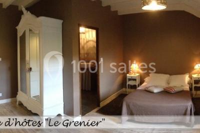 Table en bois décorée pour un repas festif, avec bougies, fleurs et vaisselle, dans une salle aux murs en pierre.