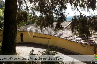 Table en bois décorée pour un repas festif, avec bougies, fleurs et vaisselle, dans une salle aux murs en pierre.