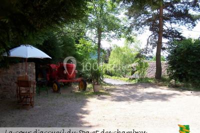 Table en bois décorée pour un repas festif, avec bougies, fleurs et vaisselle, dans une salle aux murs en pierre.