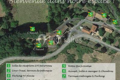 Table en bois décorée pour un repas festif, avec bougies, fleurs et vaisselle, dans une salle aux murs en pierre.